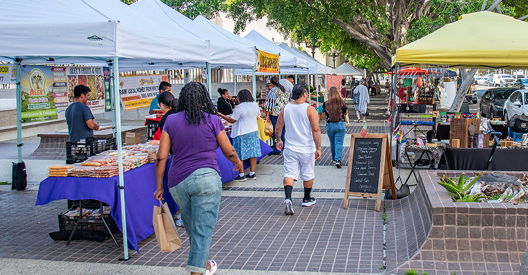 People exploring a farmers market in LA